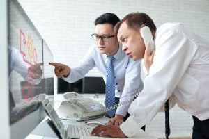 Office setting with employees analyzing reports on a computer